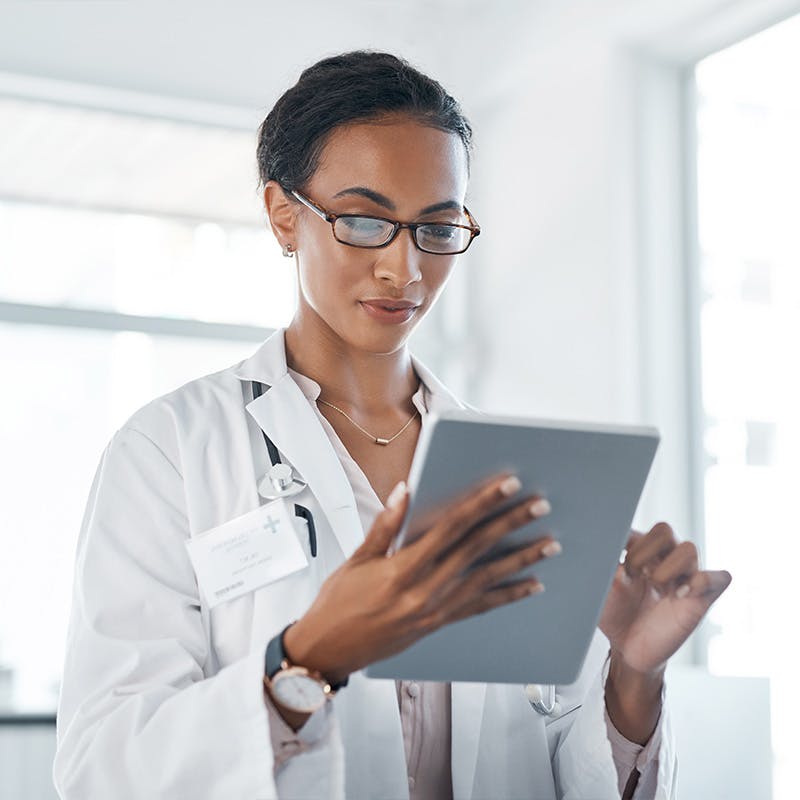 Shot of a young doctor using her digital tablet at work