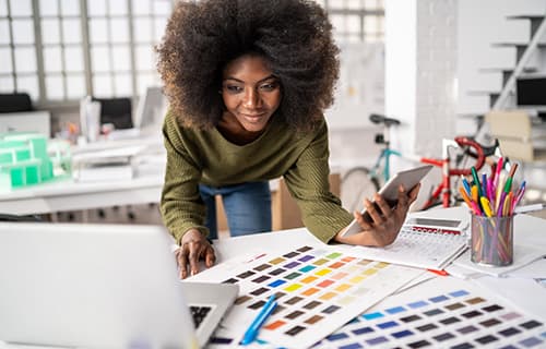businesswoman working in studio and using laptop and smart phone