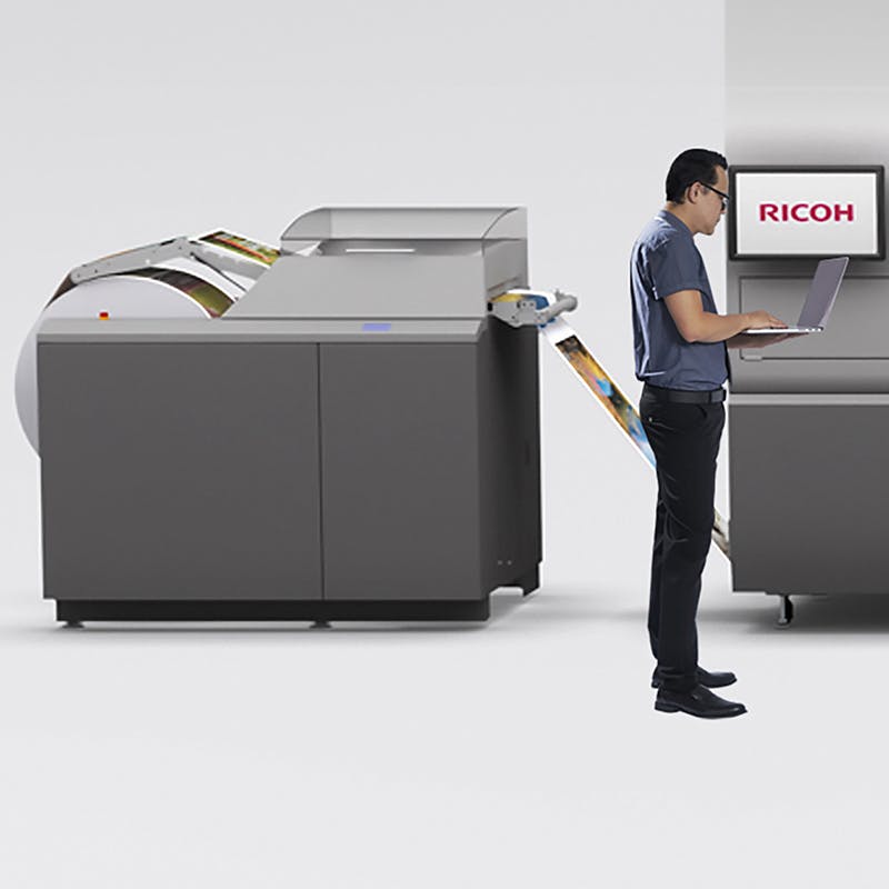 Ricoh technician working on a VC70000 printer