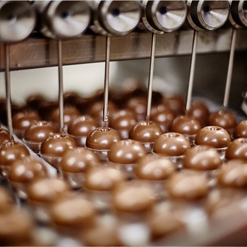 Chocolates on a conveyor being filled