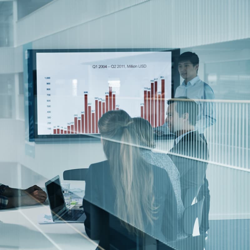 Conference room with people reviewing bar graphs