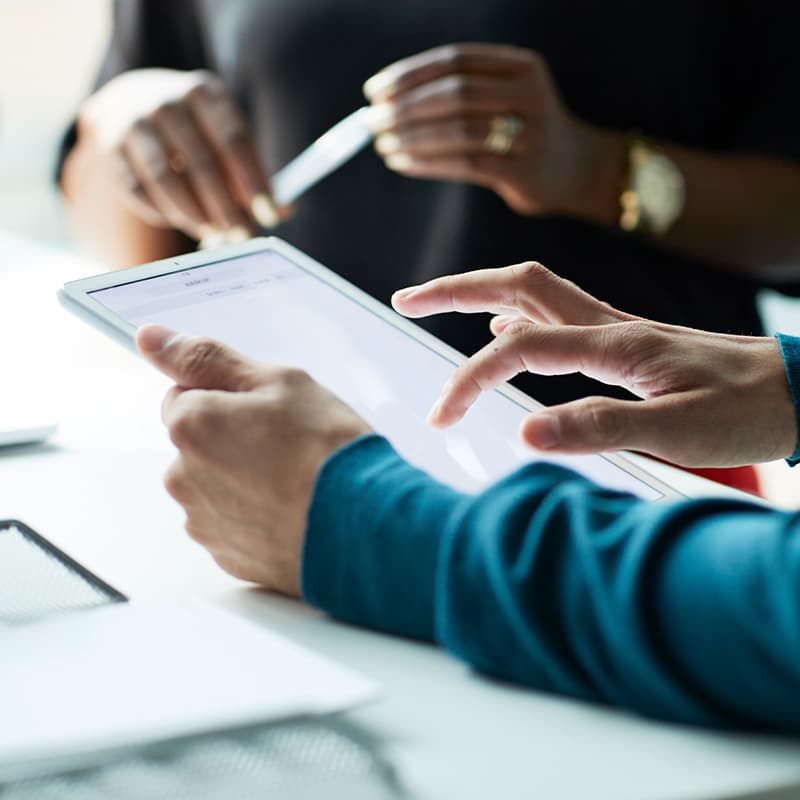 Focus on a tablet with two peoples hand in focus