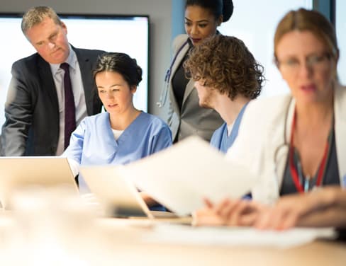 Doctors and businessmen discussing in meeting room.