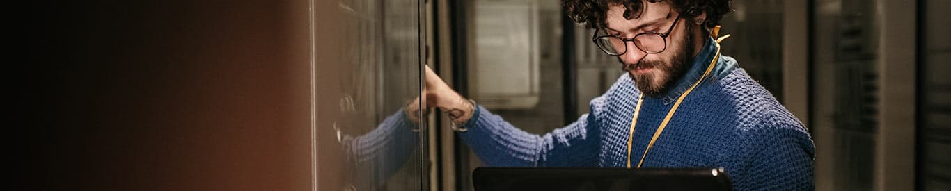 Man looking at laptop while working on a server