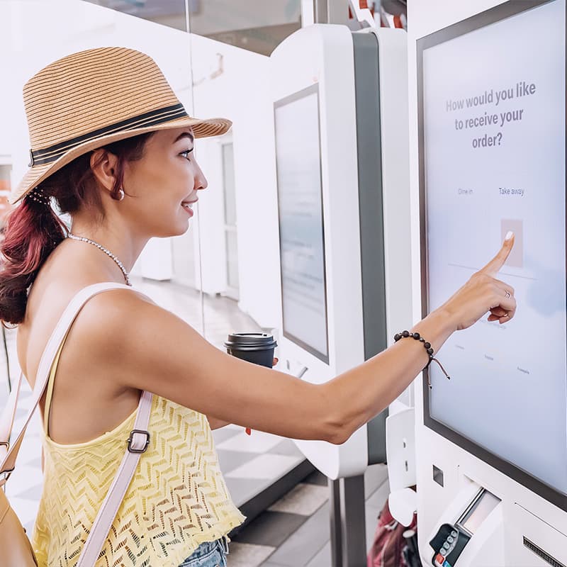 Woman using self service kiosk